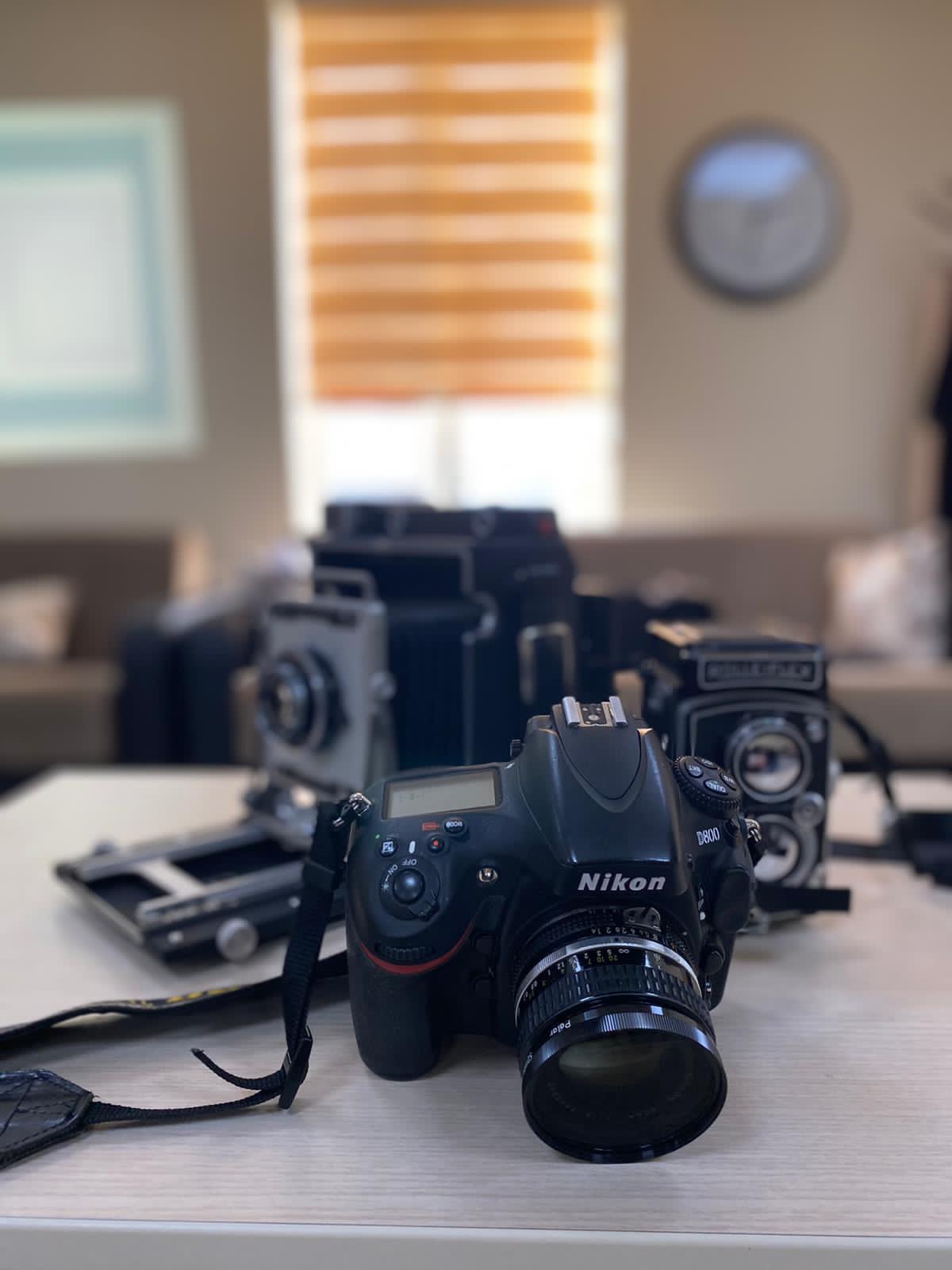 Vintage and modern cameras on a table, used in the course