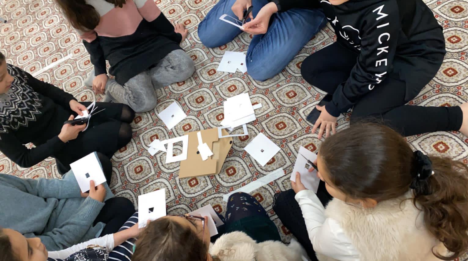Paper frames and photo cards on the floor during a group exercise